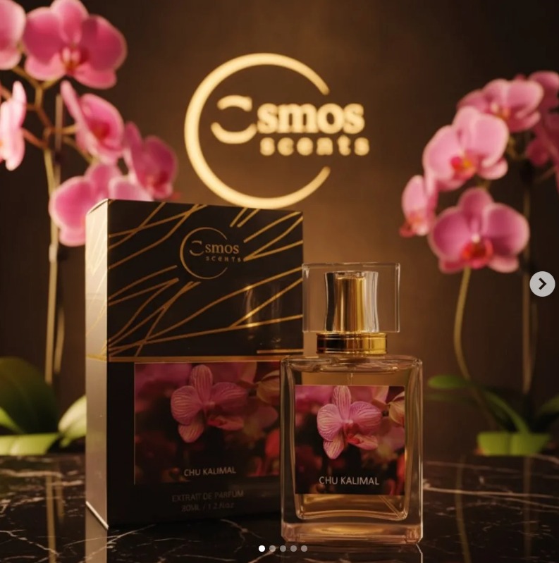 Cosmos Scents Fine Fragrance bottle surrounded by white blossom petals